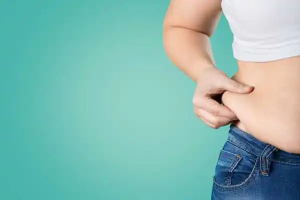 Image of woman pinching her love handles to show weight gain Inverness